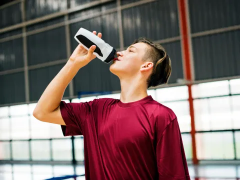 A woman drinking water after exercising.