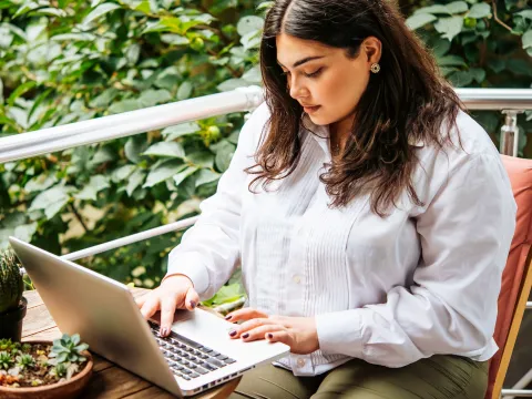 Woman on her laptop outside.