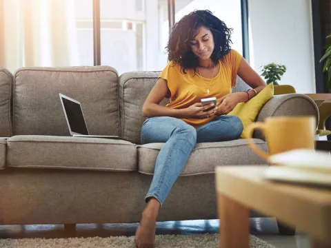 Woman reading phone on couch