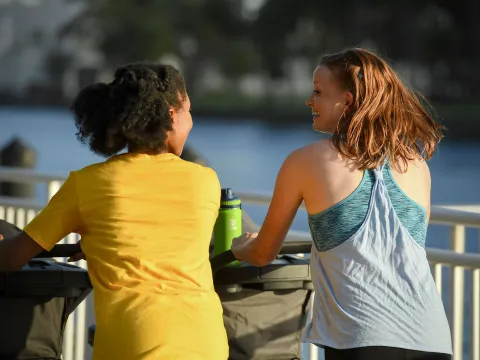 Friends exercising with their babies' strollers in the lakeside.