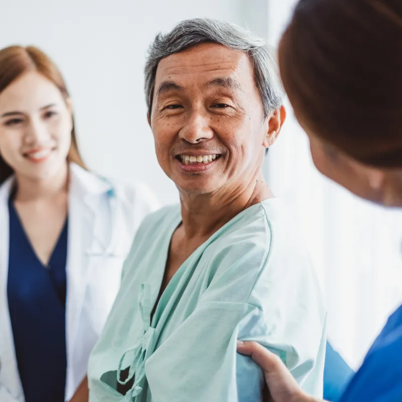 Patient smiling while a nurse holds his arm