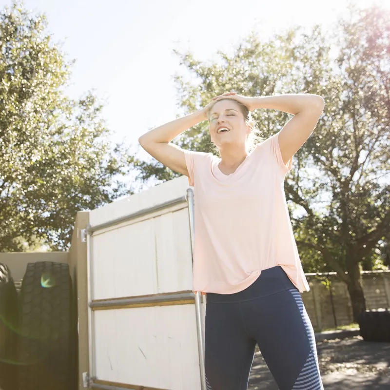 A young Caucasian woman catches her breath during outdoor exercise.