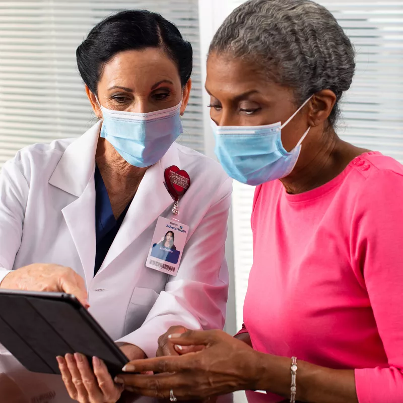 A doctor showing a patient something on her business tablet