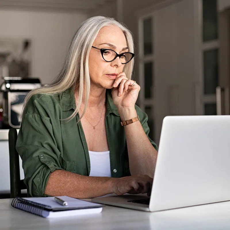 A woman in her office and on the laptop