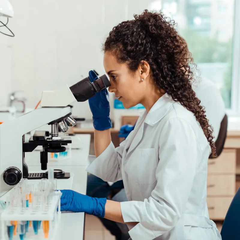 A woman researcher using a microscope.