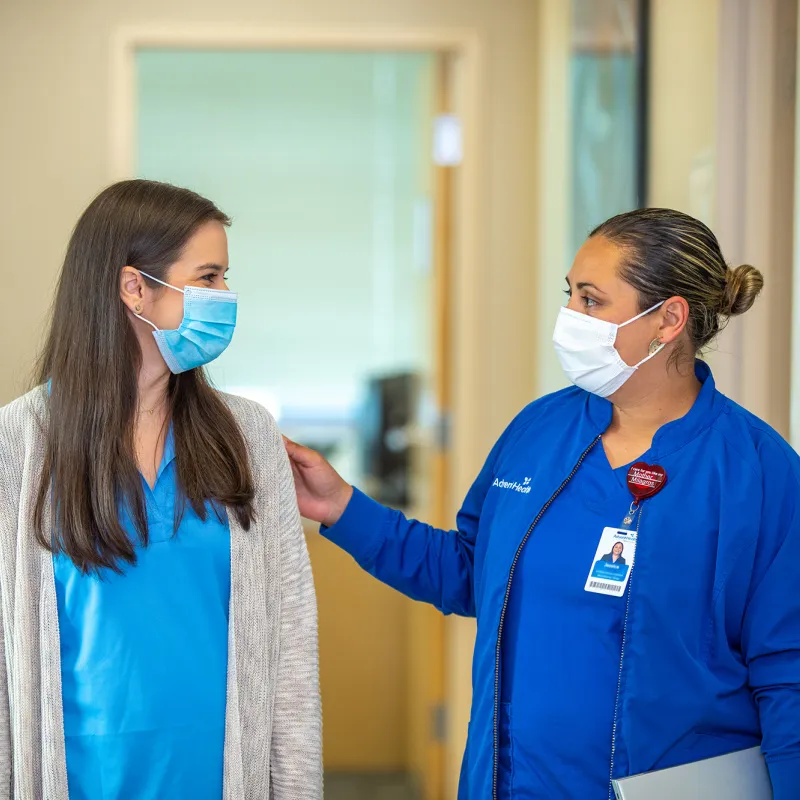 Nurse with her hand on patient in hallway at outpatient clinic