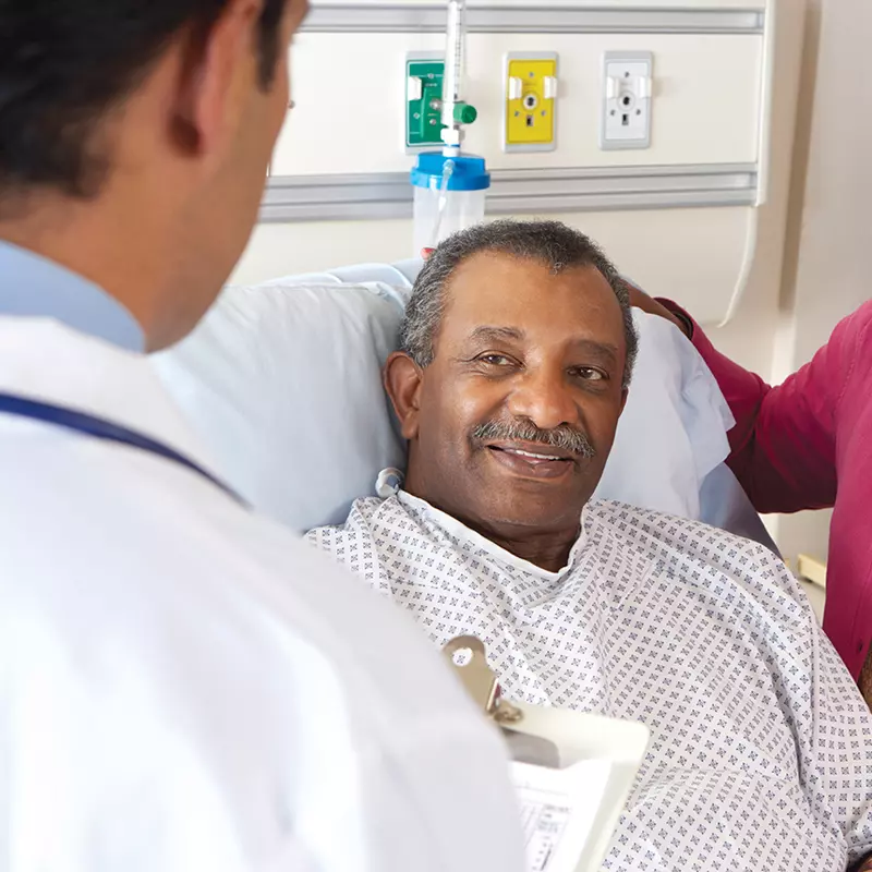 Doctor visiting patient in bed.