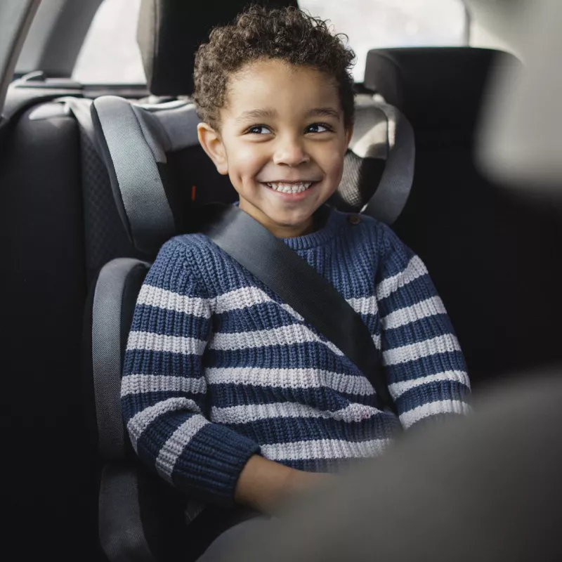 A little boy in a carseat.