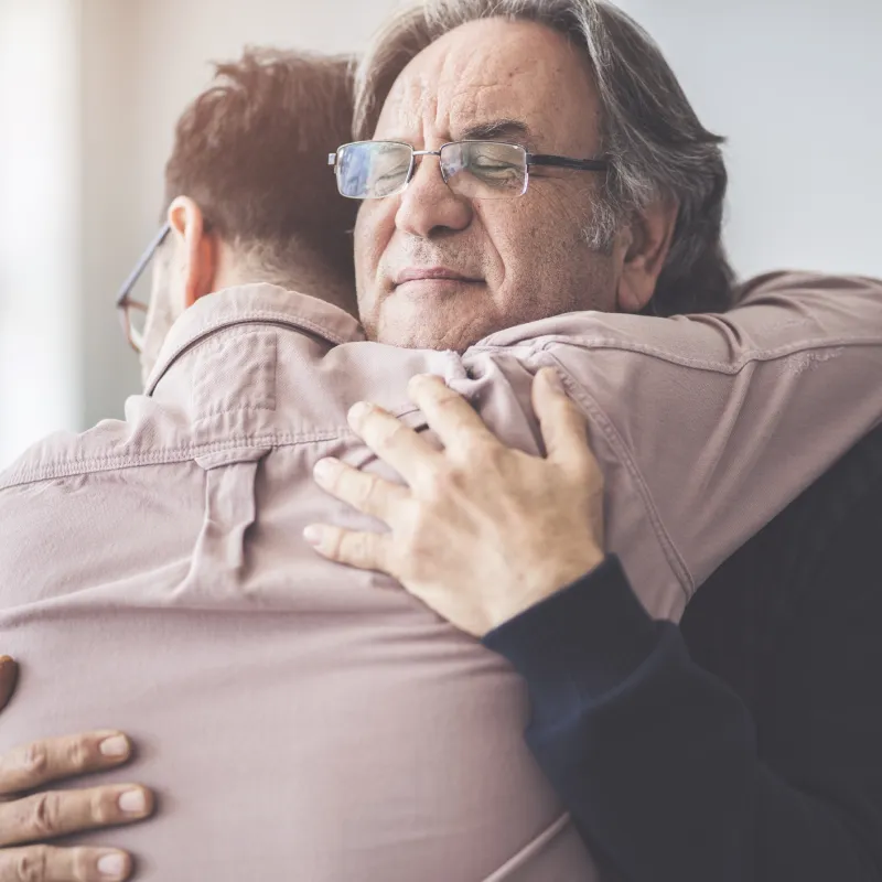 Two men are hugging comfort each other in their time of need.