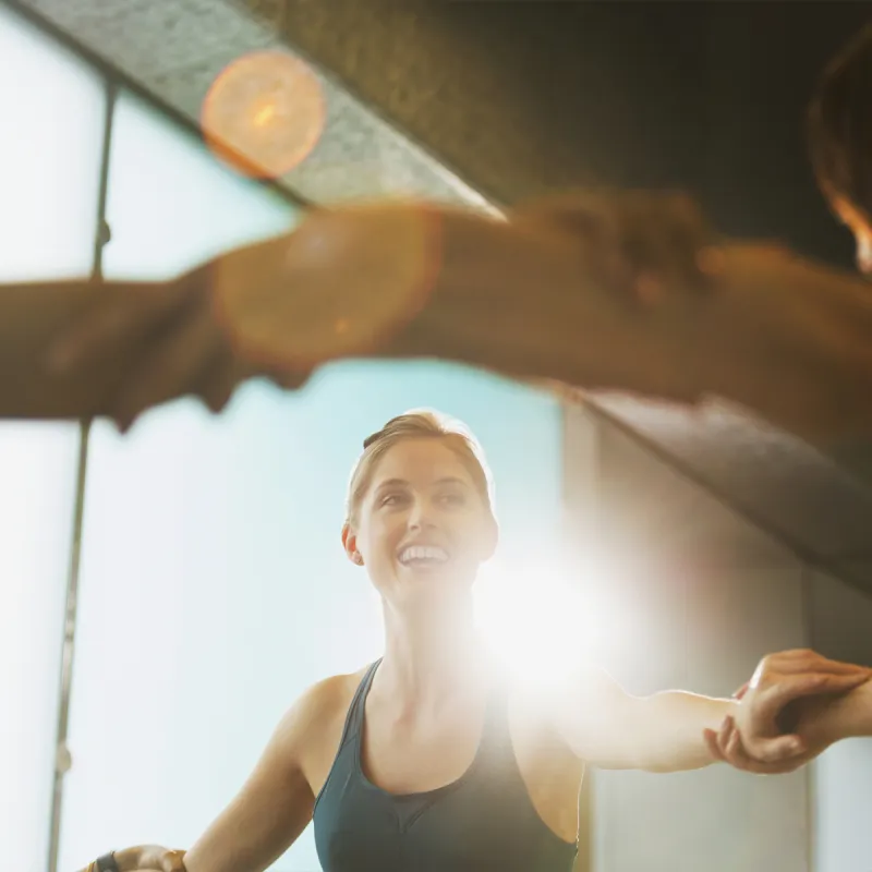 A young Caucasian woman joins her peers in an exercise class.