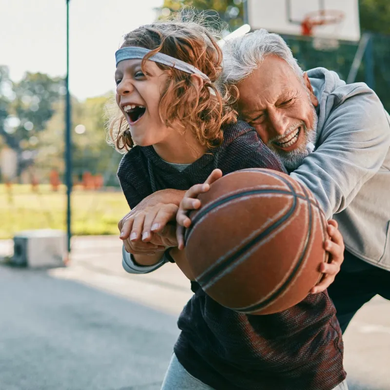 A boy and his grandpa shoot around