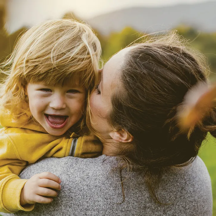 Mother holding smiling daughter