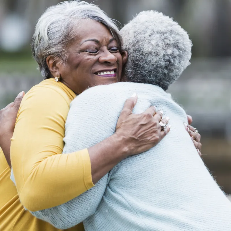 Two lifelong friends hugging.