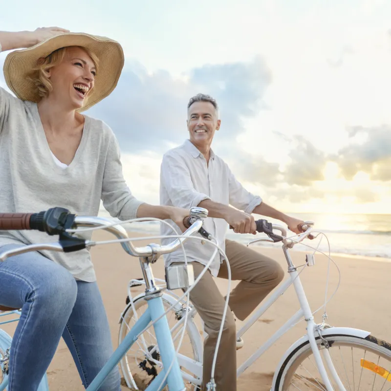 couple riding bikes on the beach