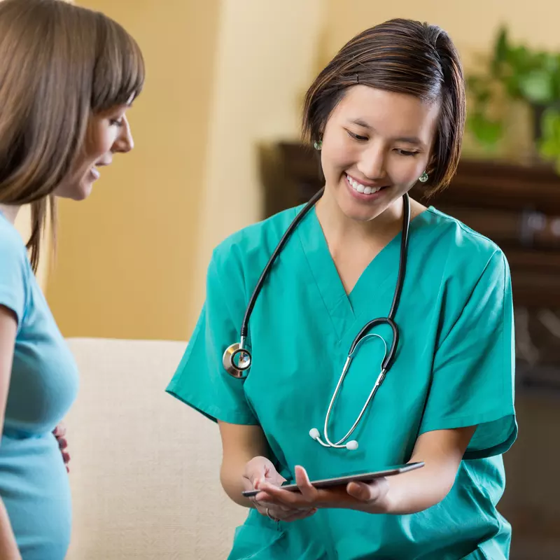 A woman discusses health symptoms with her doctor.