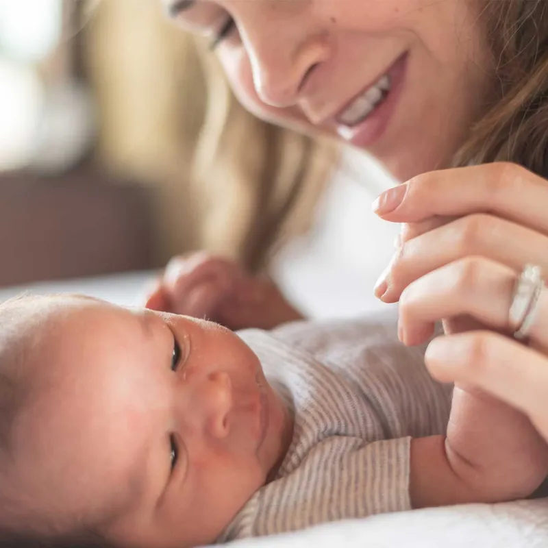 A mother holding her newborn's arms