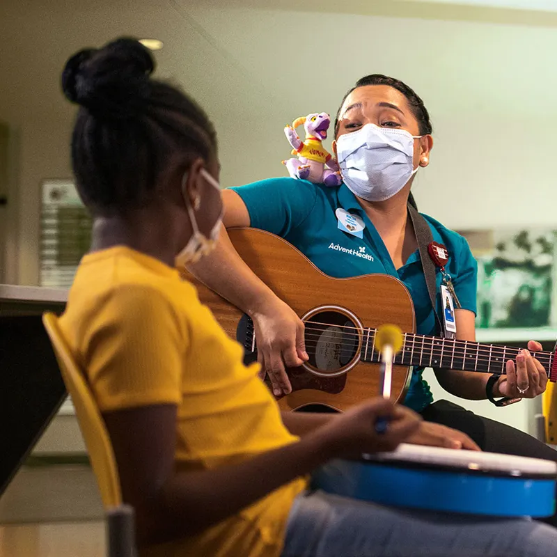 AdventHealth for Children employees playing musical instruments with young patients.