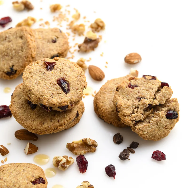 Six cranberry-walnut cookies amid almonds and craisins