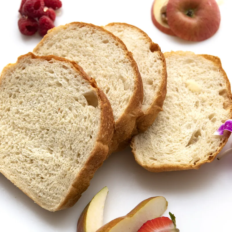 Four slices of bread, an orchid, apples slices, and blueberries.