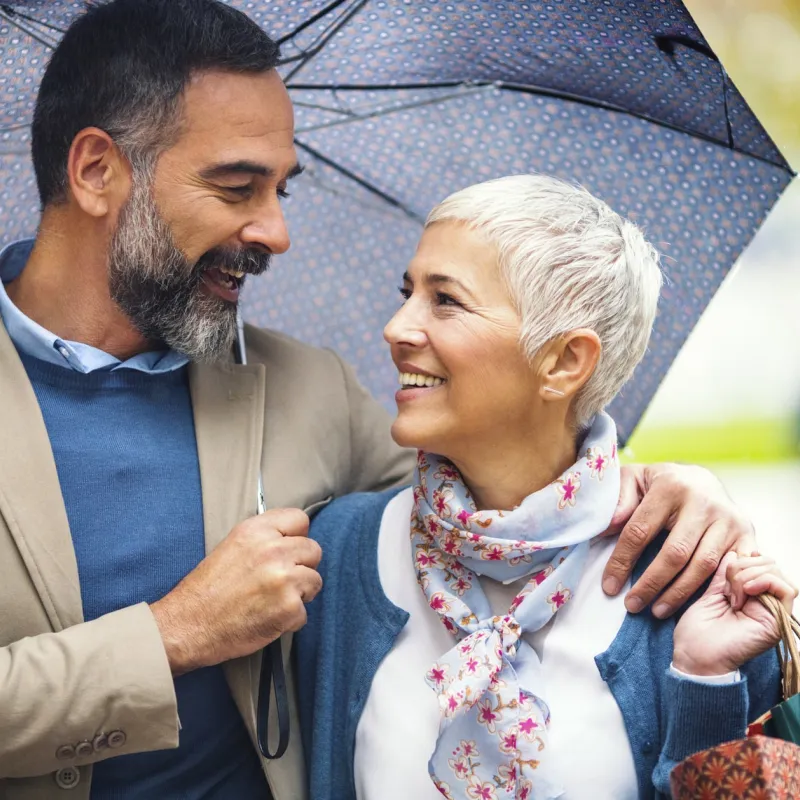 A couple takes a walk under an umbrella.