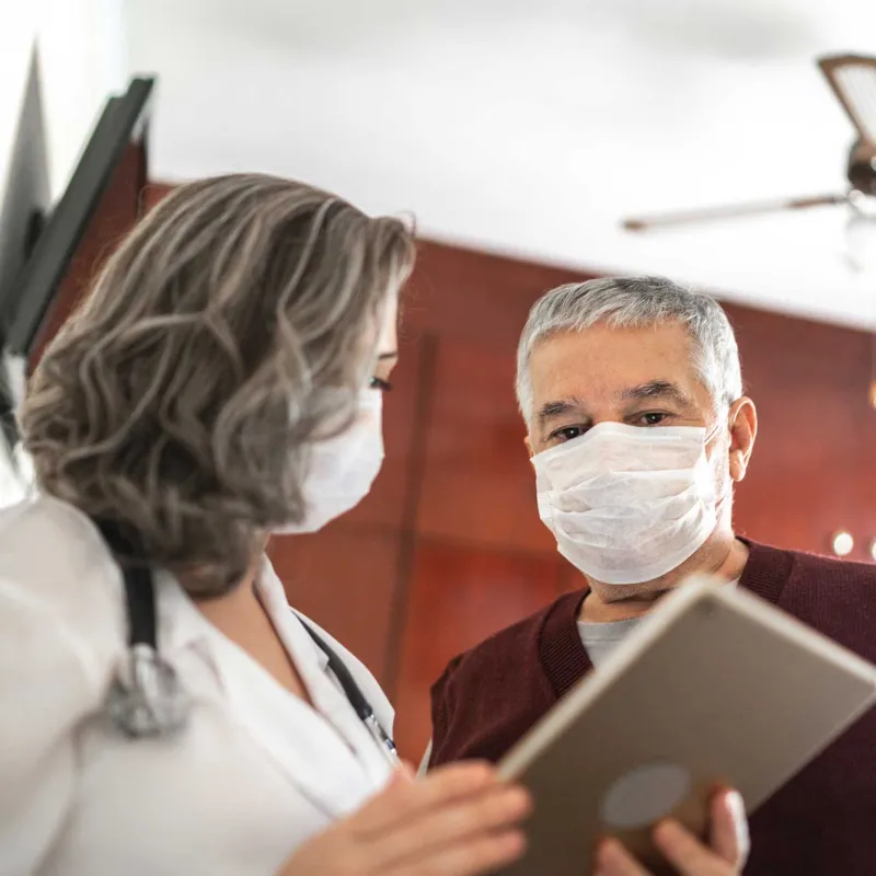 Mature female doctor talking to a male patient