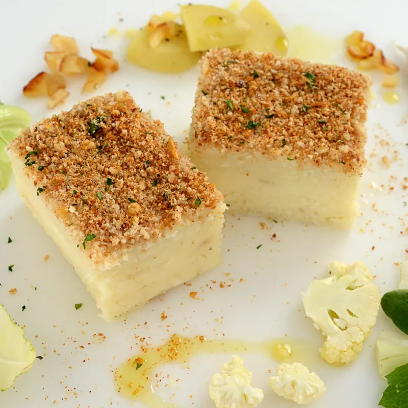 Pureed cauliflower molded into a cube with a crispy breadcrumb topping