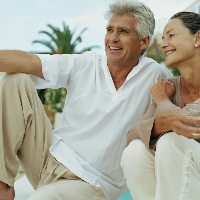 A senior couple, sitting and relaxing, drinking water together.