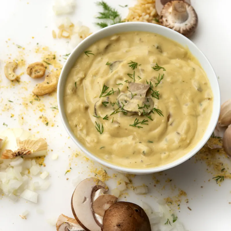 Bowl of stroganoff with cashew and mushroom garnishes