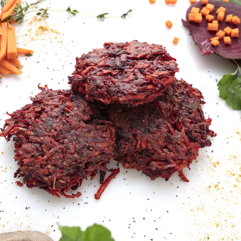 Three shredded-beet patties with carrot stick garnish