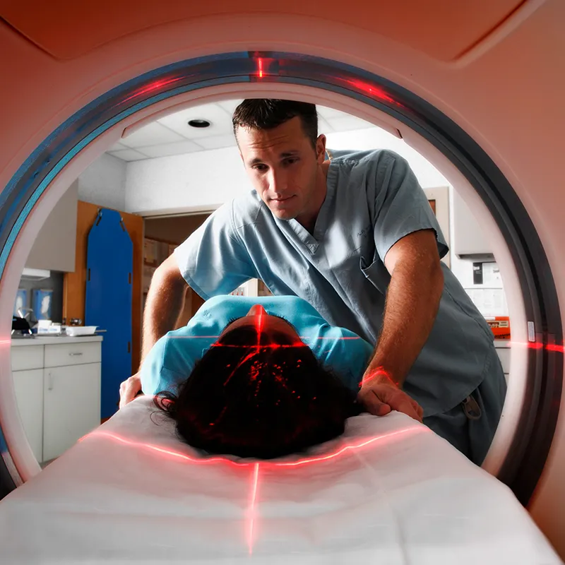 CT tech assisting patient while she gets a scan