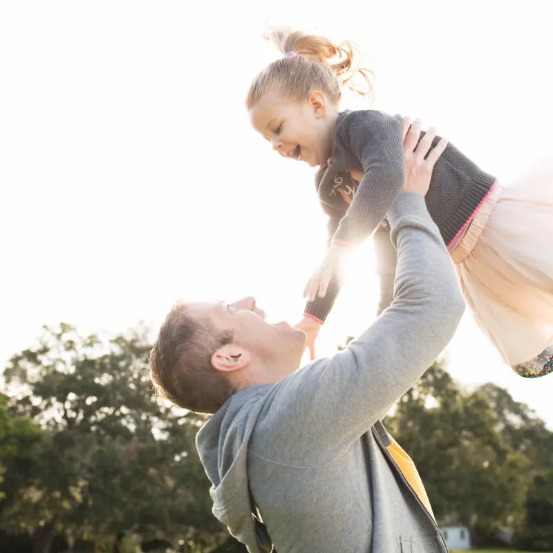 Daughter flying with Father outdoors