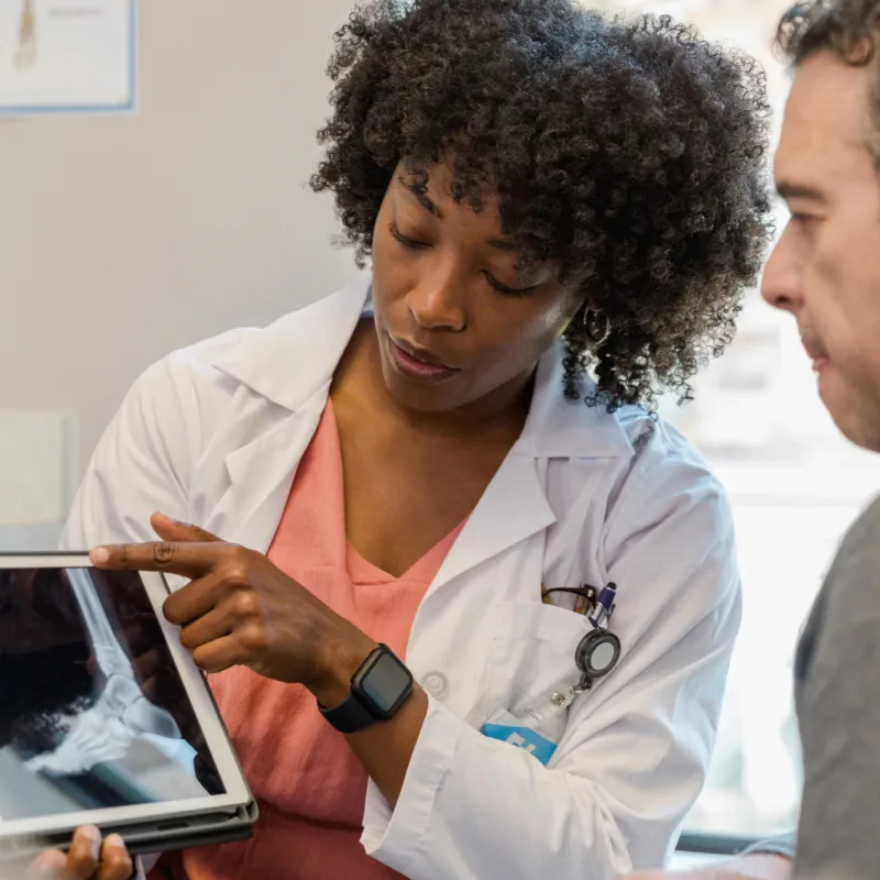 Doctor showing a man an x-ray of his foot.