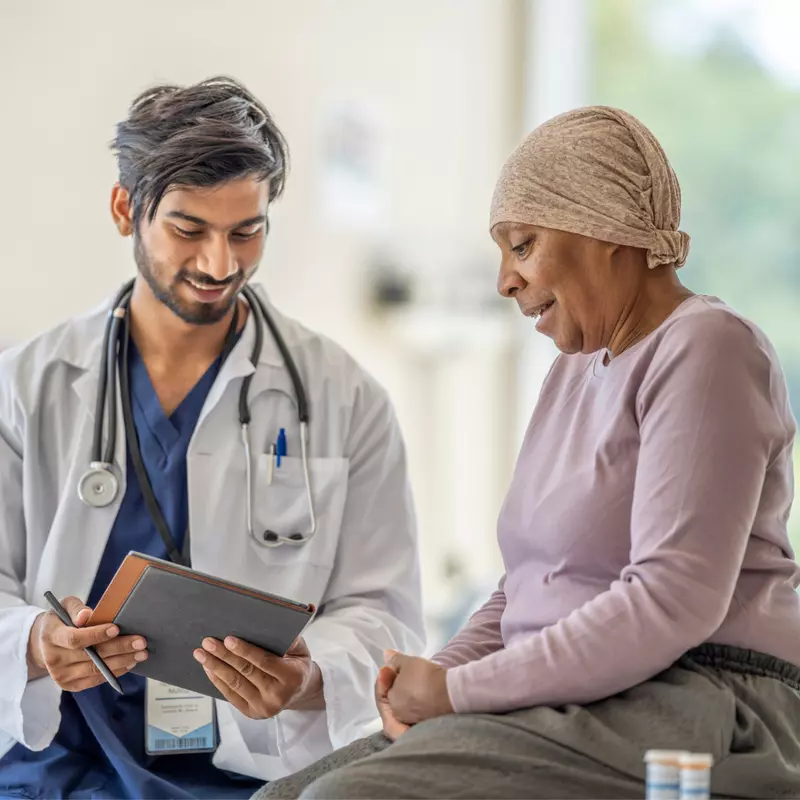 Doctor explaining to an older woman cancer patient her test results.