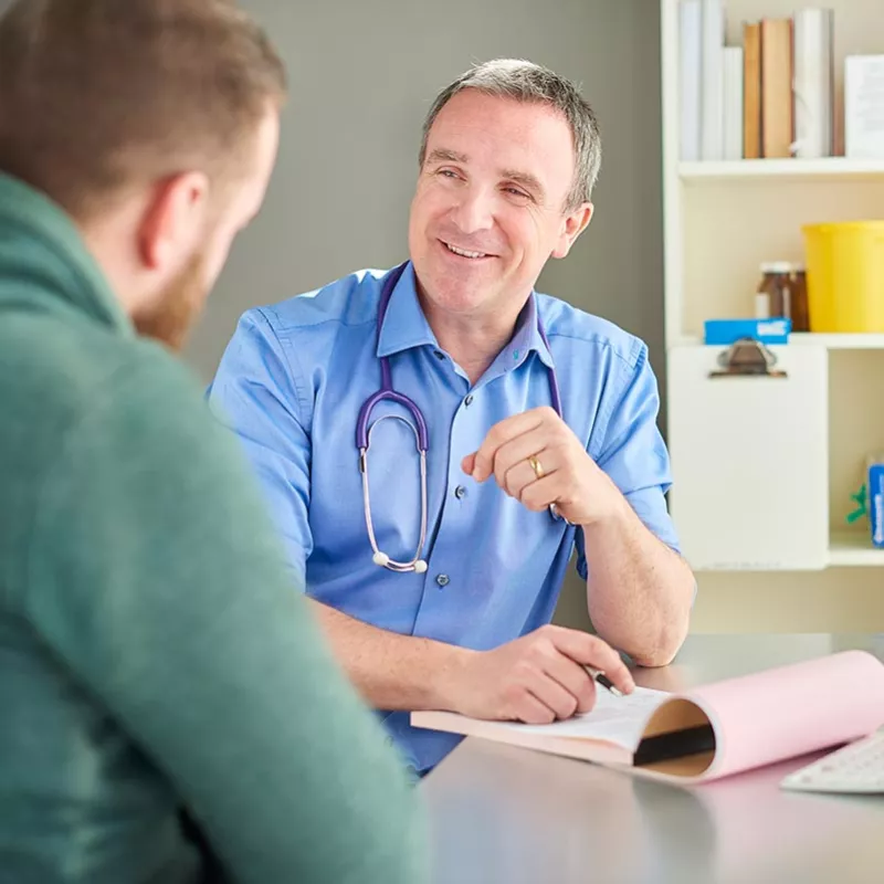 Doctor casually talking with patient while taking notes