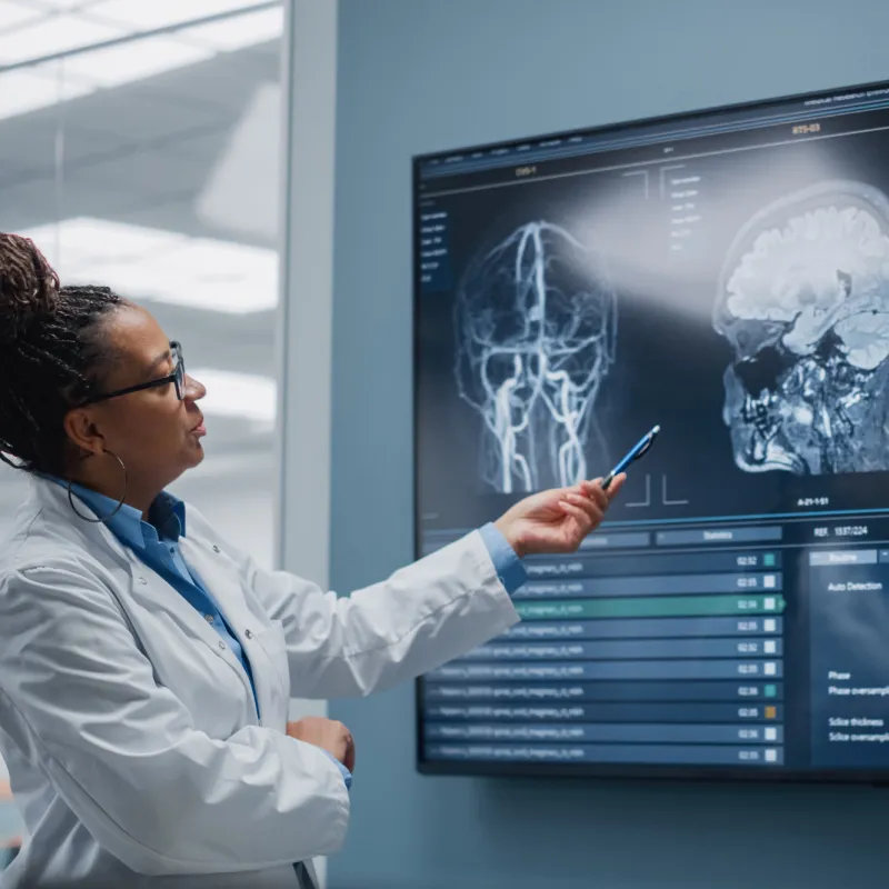 Two doctors discussing MRI scans of a head.