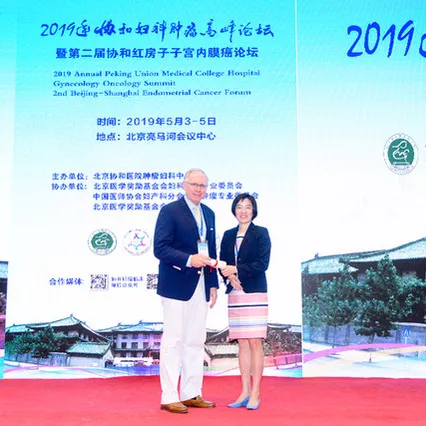 Dr. Robert Holloway receiving an award from a woman