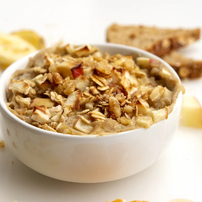 Bowl of cooked apples and oat with apple chunk garnish