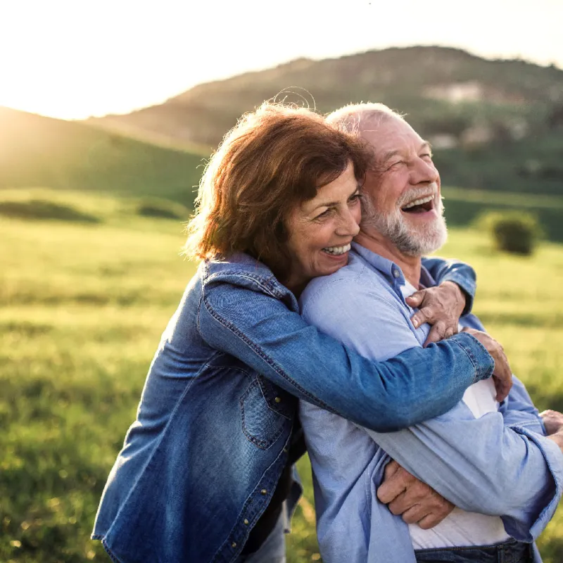 A mature wife hugging her husband outdoors