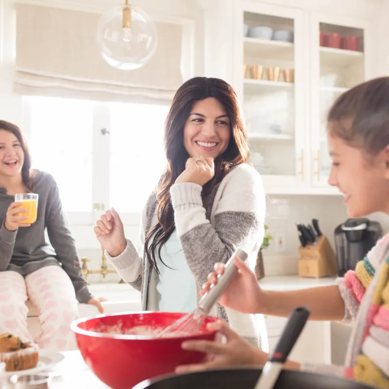 Mother baking with her daughters in the kitchen.