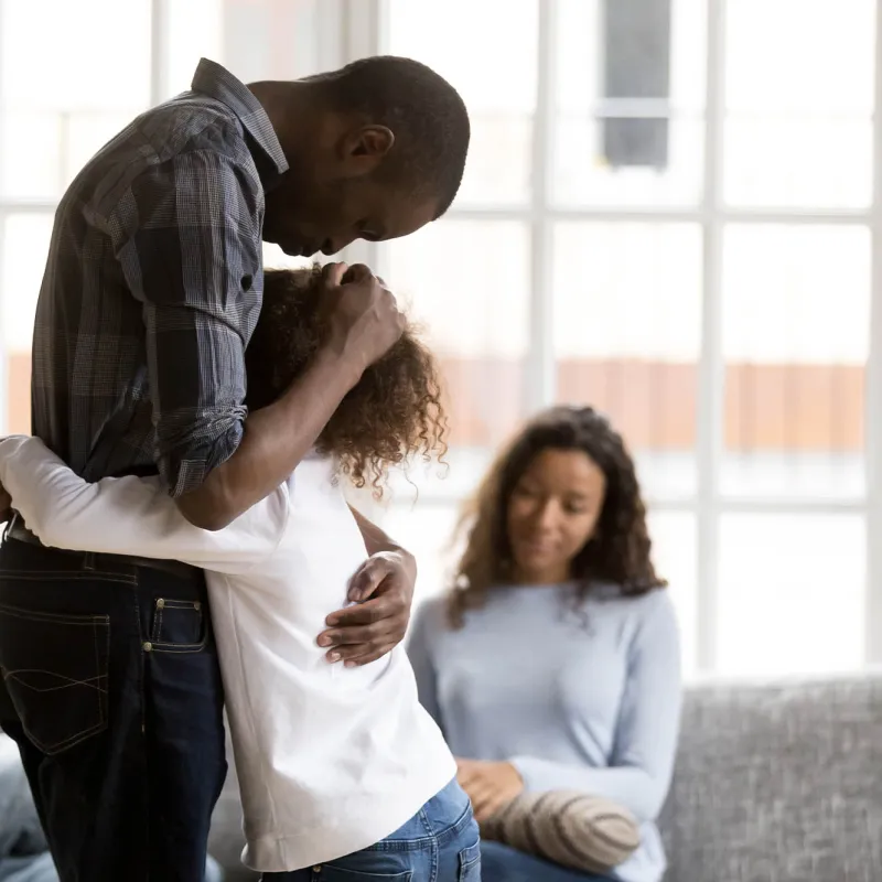 A father consoling his young daughter. 