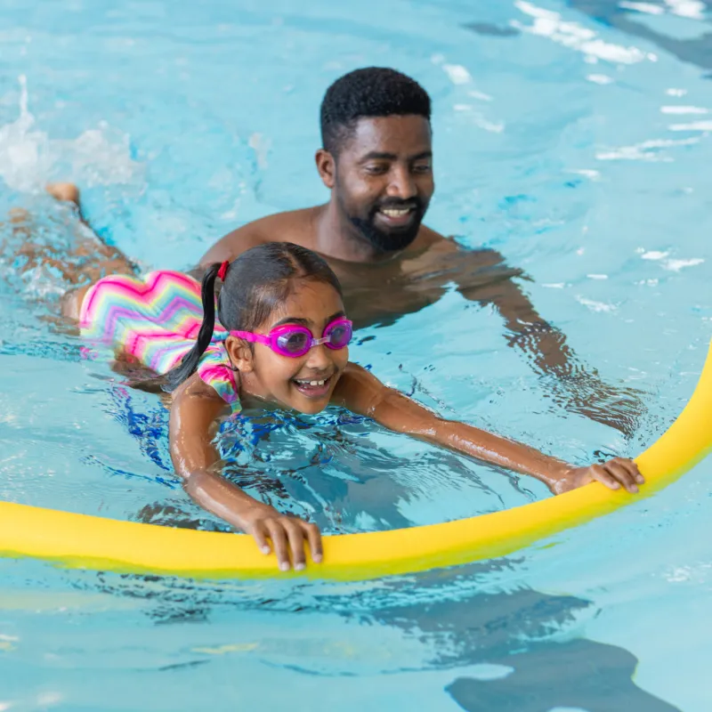 Father and Daughter swimming together at the pool.