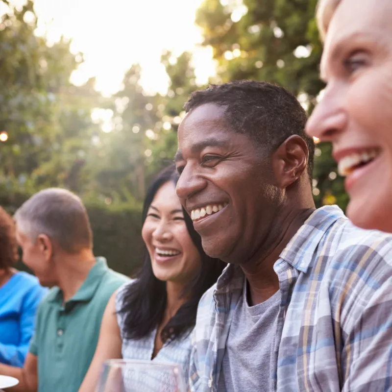 Friends sitting outdoors at a table during a dinner party.