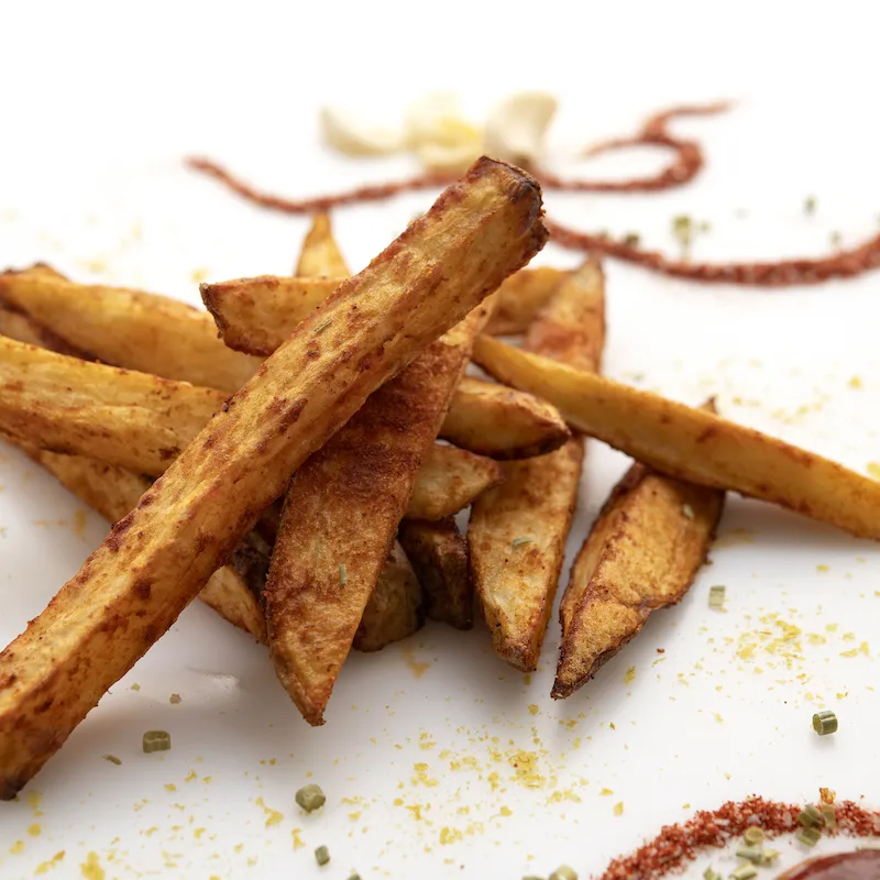 Small pile of French fries on a white counter.