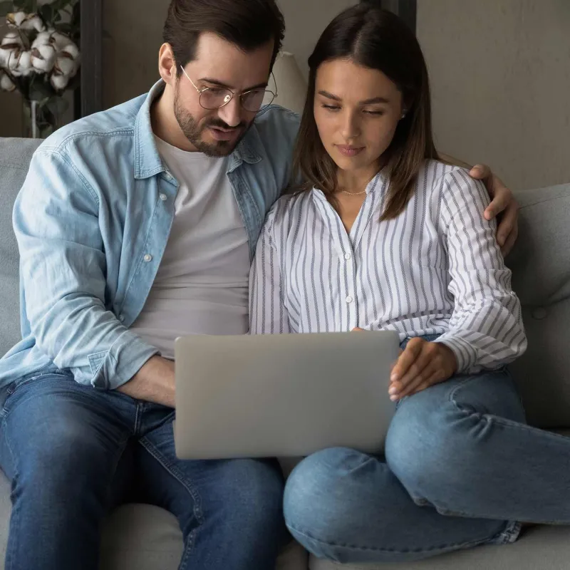 A young, married couple on their laptop