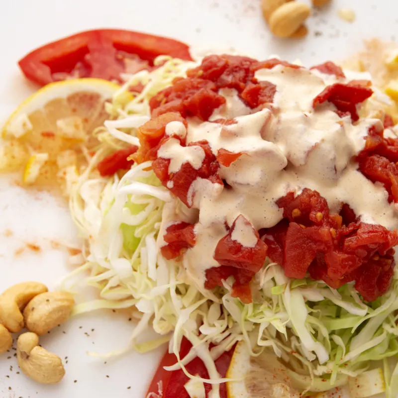 Mound of tomato slaw with lemon and tomato garnish