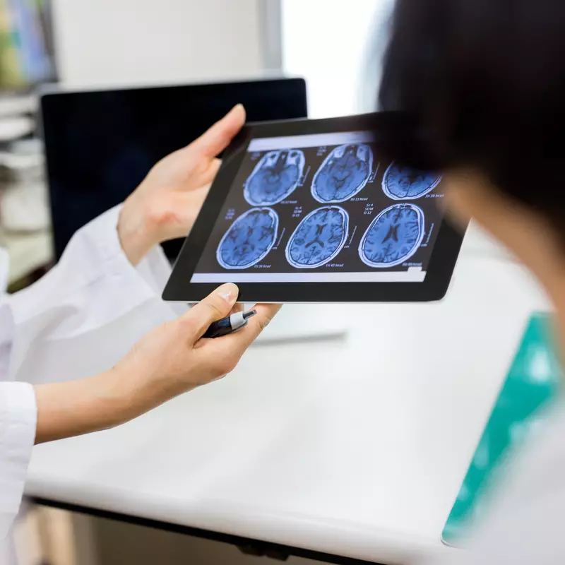 A hospital care team reviews scans of a patient's brain