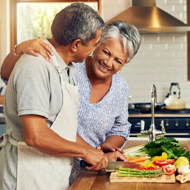 A couple prepares a meal full of vegetables.