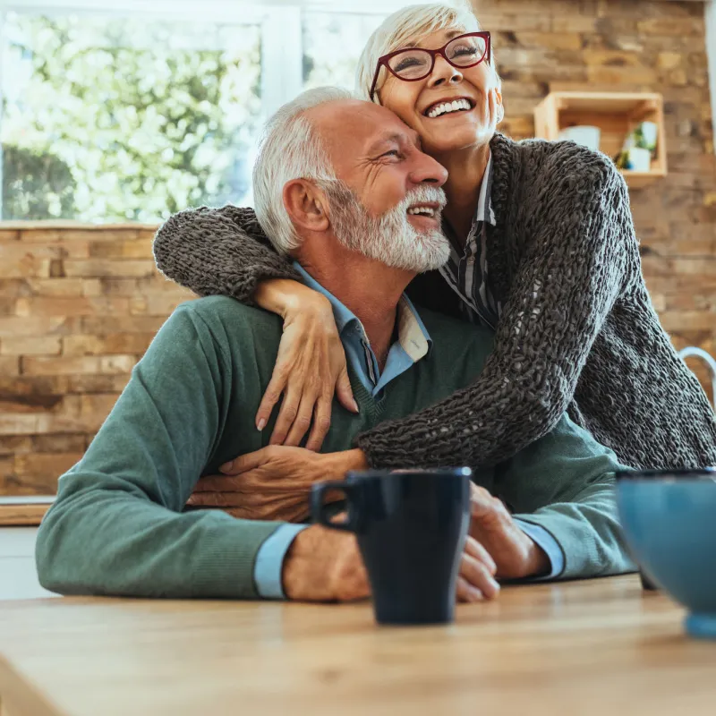 A couple hugging in the kitchen.