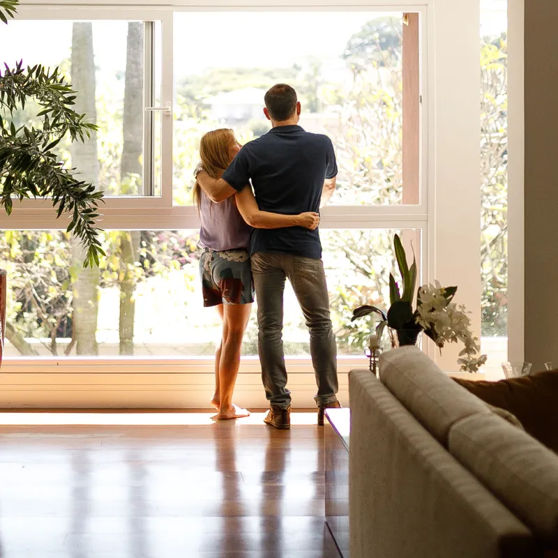 A couple hugging and looking out a window.