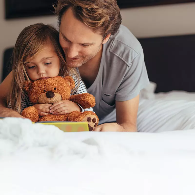 A dad and daughter reading together